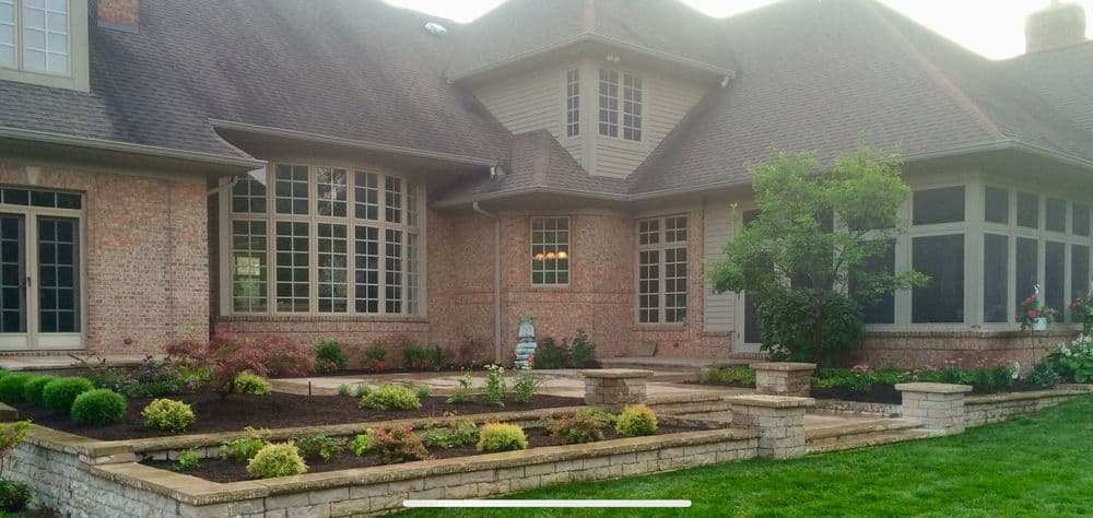 Elegant home exterior featuring brick facade, large windows, and landscaped garden.